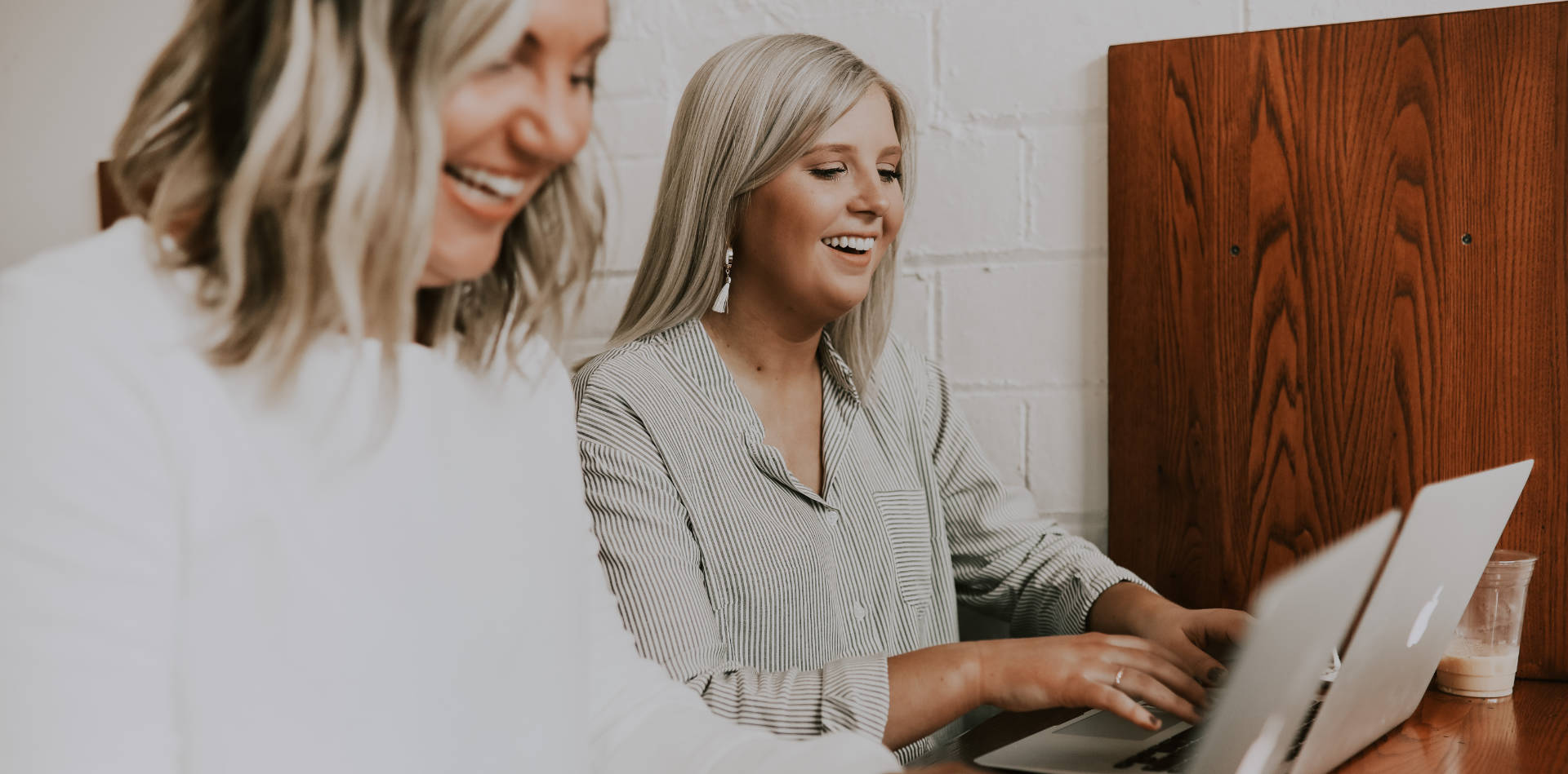 Zwei Frauen freuen sich am Laptop über E-Commerce Schnittstellen